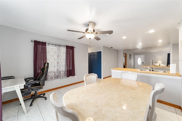 dining area featuring ceiling fan, light tile patterned flooring, and sink