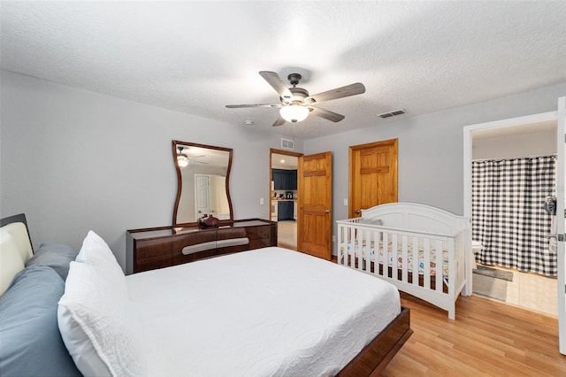 bedroom featuring ceiling fan, a textured ceiling, and light hardwood / wood-style floors