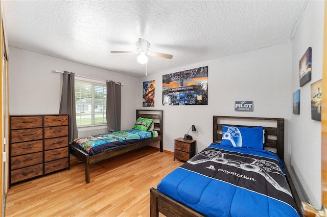 bedroom featuring a textured ceiling, wood-type flooring, and ceiling fan