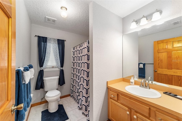 bathroom featuring tile patterned flooring, a textured ceiling, vanity, and toilet