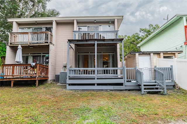 back of house with a balcony and a lawn