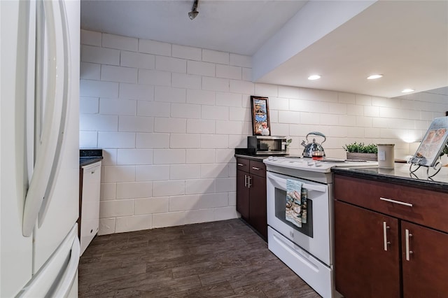 kitchen featuring dark brown cabinetry, tile walls, and white appliances