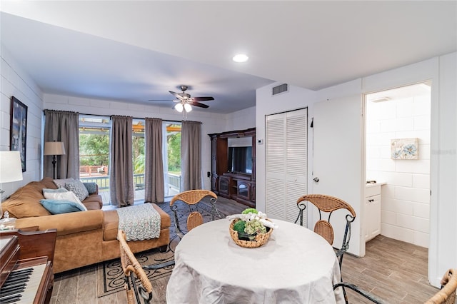 dining area with light wood-type flooring and ceiling fan