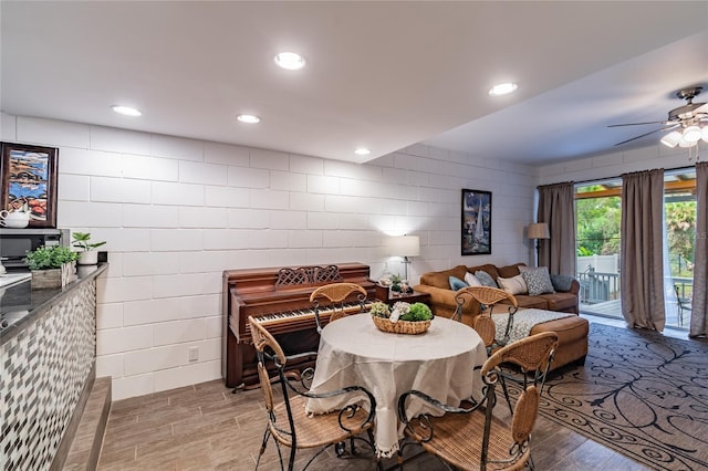 dining room with ceiling fan, light wood finished floors, tile walls, and recessed lighting