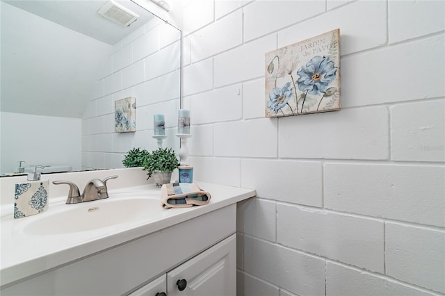 bathroom with vaulted ceiling and vanity