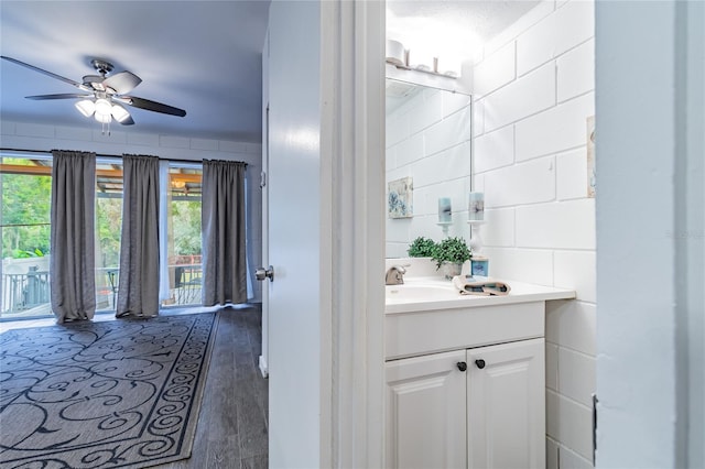 bathroom with ceiling fan, vanity, and wood-type flooring