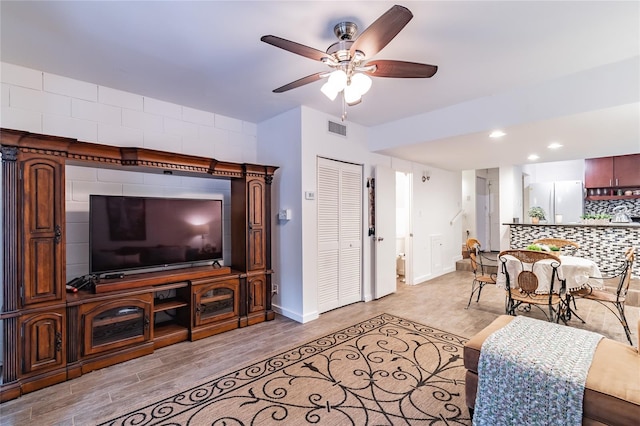 living room with light wood-type flooring and ceiling fan