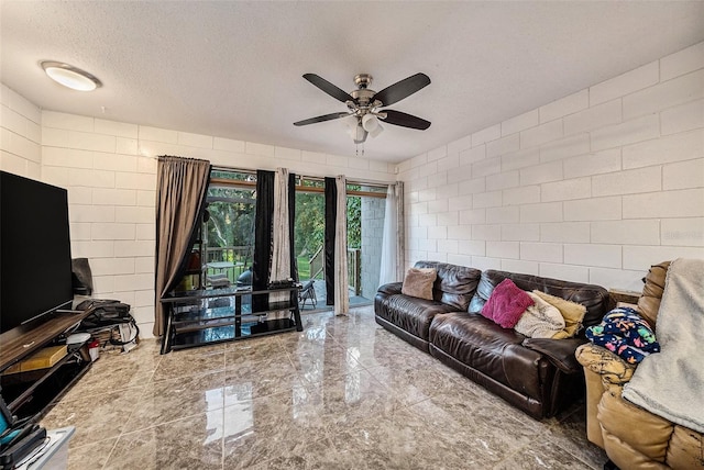 living room with a textured ceiling and ceiling fan