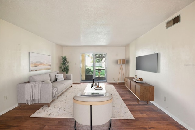 living room featuring a textured ceiling and dark hardwood / wood-style flooring