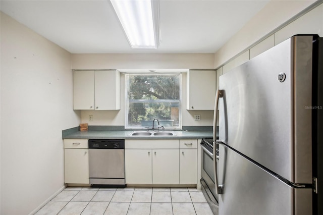 kitchen with light tile patterned floors, appliances with stainless steel finishes, sink, and white cabinetry