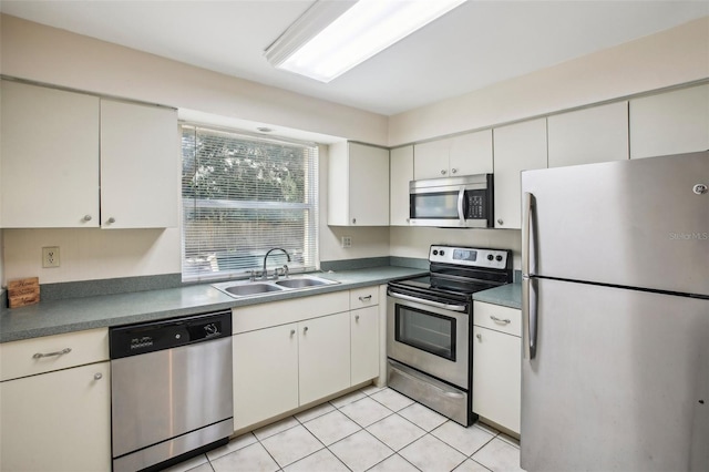 kitchen with light tile patterned floors, white cabinets, appliances with stainless steel finishes, and sink