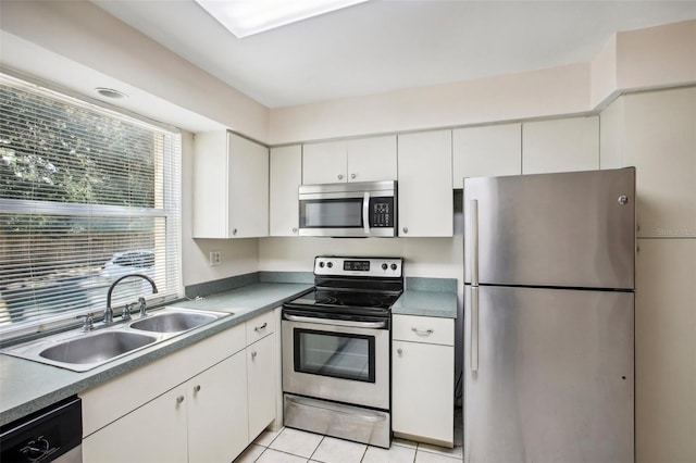 kitchen with stainless steel appliances, white cabinetry, light tile patterned floors, and sink