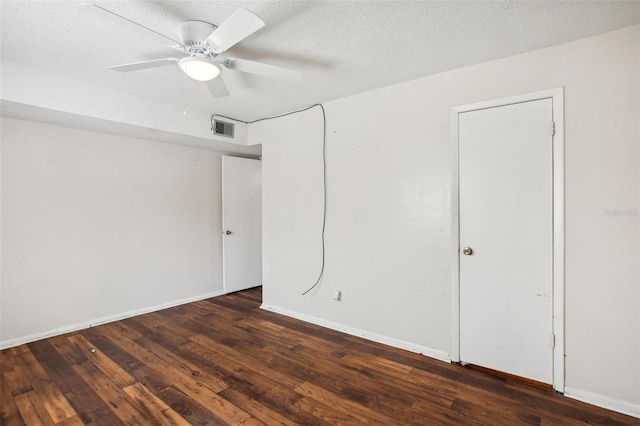 unfurnished bedroom with a textured ceiling, dark hardwood / wood-style floors, and ceiling fan