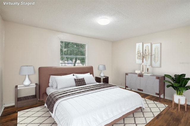 bedroom with wood-type flooring and a textured ceiling