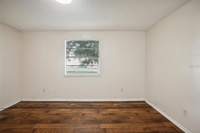 spare room featuring a textured ceiling and dark wood-type flooring