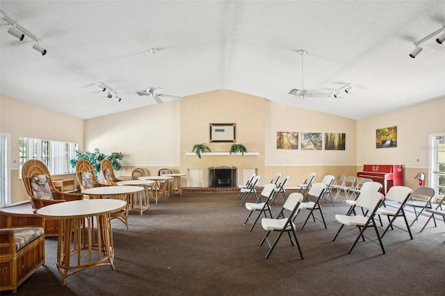 dining space with ceiling fan, track lighting, and vaulted ceiling