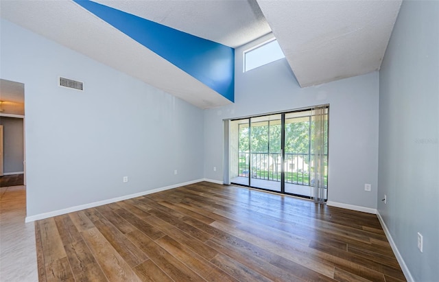 unfurnished room with dark hardwood / wood-style floors, high vaulted ceiling, and plenty of natural light