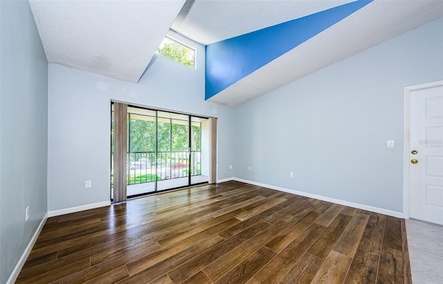 spare room featuring a textured ceiling, dark wood-type flooring, and plenty of natural light