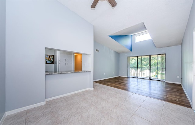 interior space with ceiling fan, light hardwood / wood-style flooring, and high vaulted ceiling