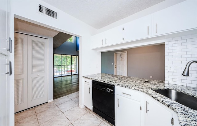 kitchen with light stone countertops, white cabinetry, a textured ceiling, and black dishwasher