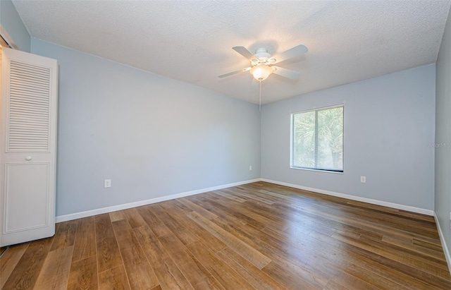 empty room featuring a textured ceiling, ceiling fan, and hardwood / wood-style flooring