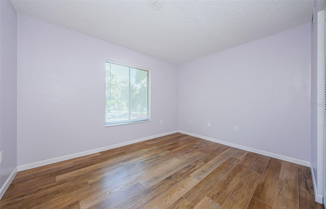 unfurnished room with a textured ceiling and hardwood / wood-style flooring