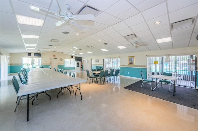 dining room with ceiling fan and a drop ceiling