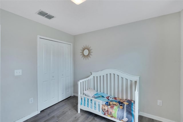 bedroom featuring hardwood / wood-style floors and a crib