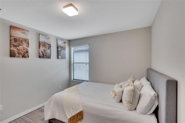 bedroom with hardwood / wood-style flooring and a textured ceiling