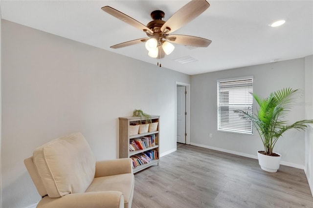 sitting room with ceiling fan and light wood-type flooring