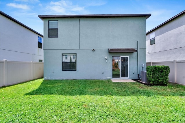 back of property with a lawn and central air condition unit