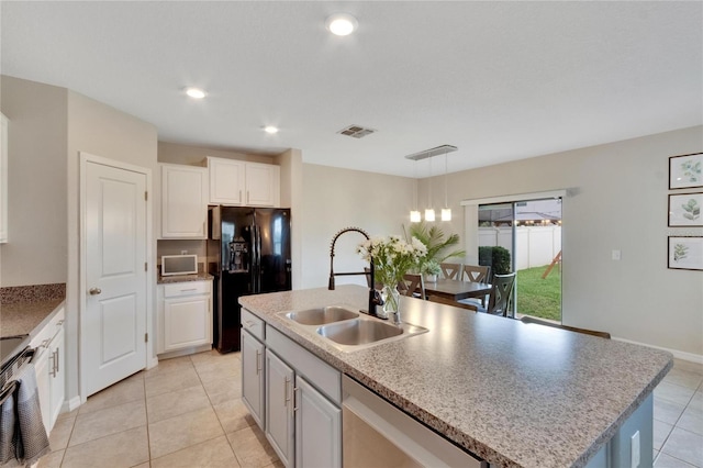 kitchen with black refrigerator with ice dispenser, sink, an island with sink, decorative light fixtures, and white cabinetry