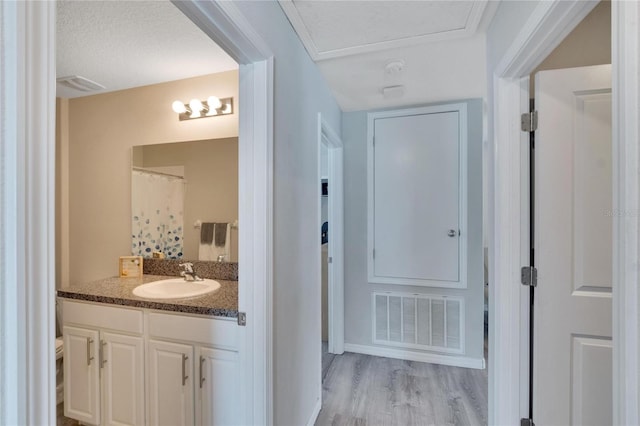 bathroom featuring hardwood / wood-style floors, vanity, a textured ceiling, and a shower with curtain