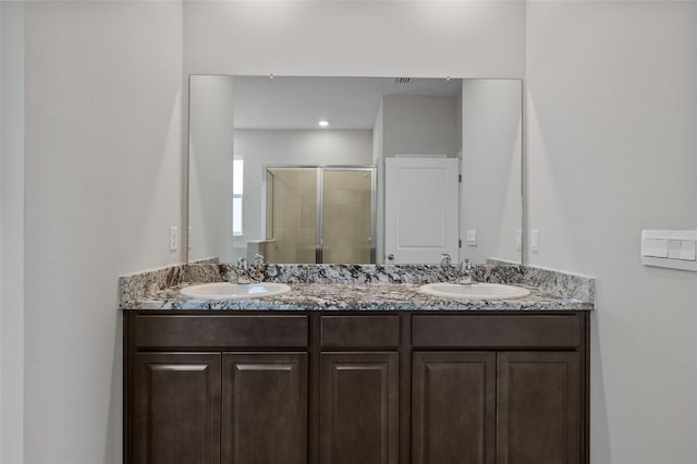 bathroom featuring vanity and a shower with shower door