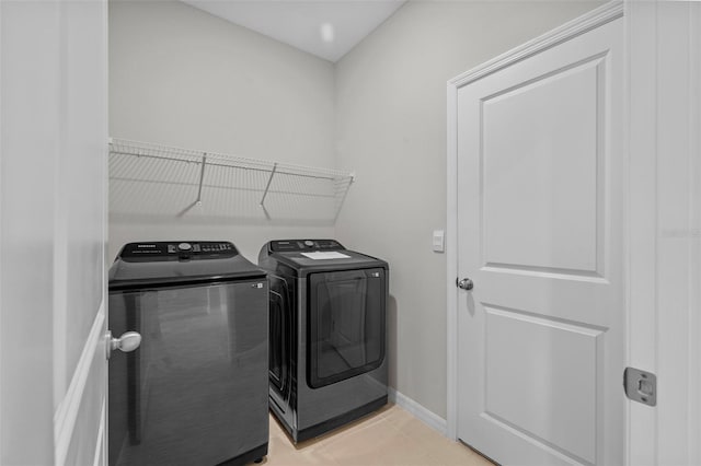 clothes washing area with light tile patterned floors and washing machine and clothes dryer