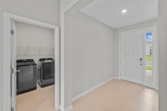 entrance foyer featuring light tile patterned flooring and separate washer and dryer