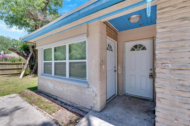 doorway to property featuring fence