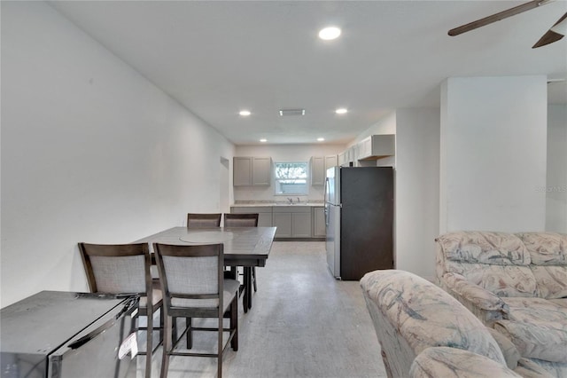 dining room with light hardwood / wood-style floors, sink, and ceiling fan