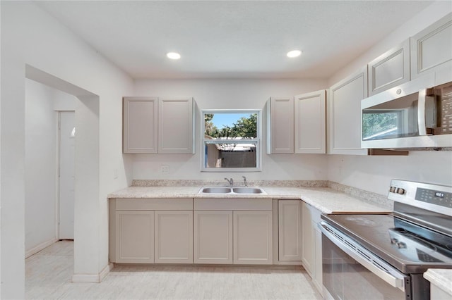 kitchen with gray cabinets, appliances with stainless steel finishes, light tile patterned floors, and sink