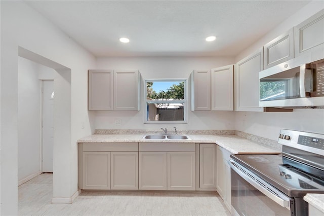 kitchen with light countertops, recessed lighting, stainless steel appliances, gray cabinetry, and a sink