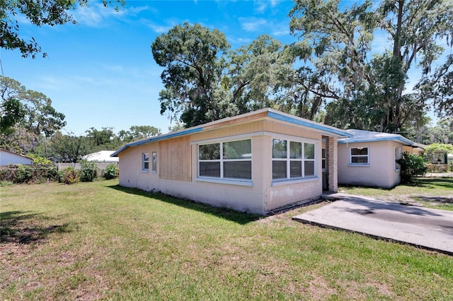 exterior space with a yard and concrete block siding