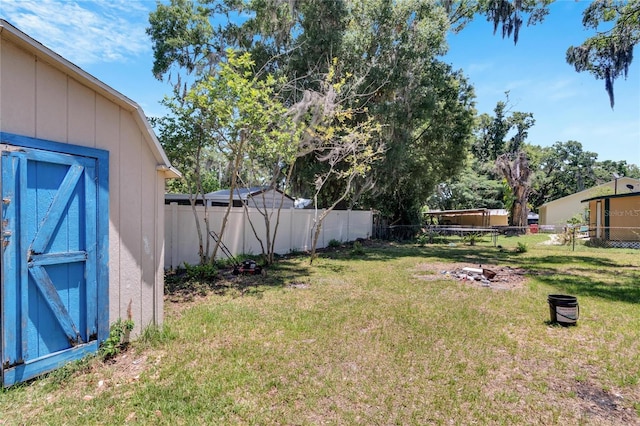 view of yard with an outbuilding, a fenced backyard, and a storage shed