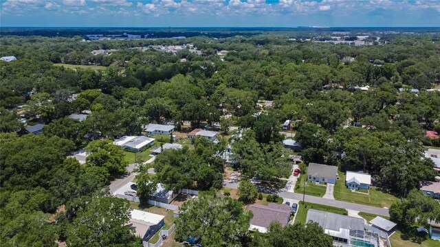 drone / aerial view featuring a wooded view and a residential view