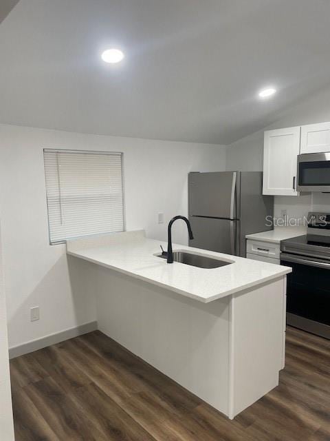 kitchen with kitchen peninsula, white cabinetry, sink, and appliances with stainless steel finishes