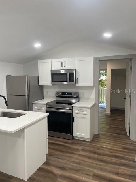 kitchen featuring stainless steel appliances, white cabinetry, dark hardwood / wood-style floors, sink, and lofted ceiling