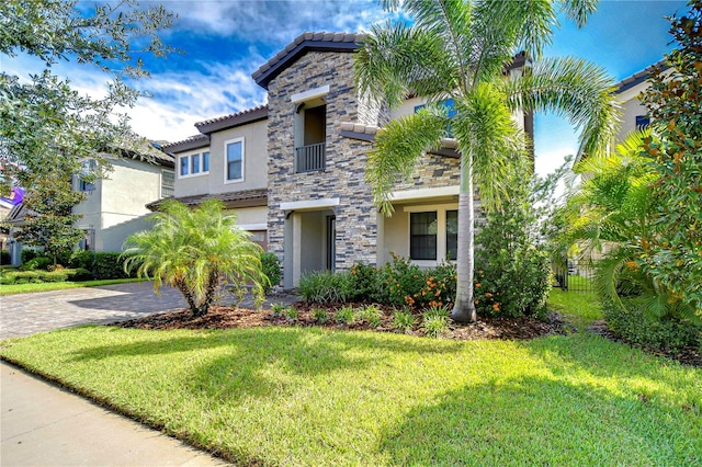 mediterranean / spanish home featuring a front lawn and a garage