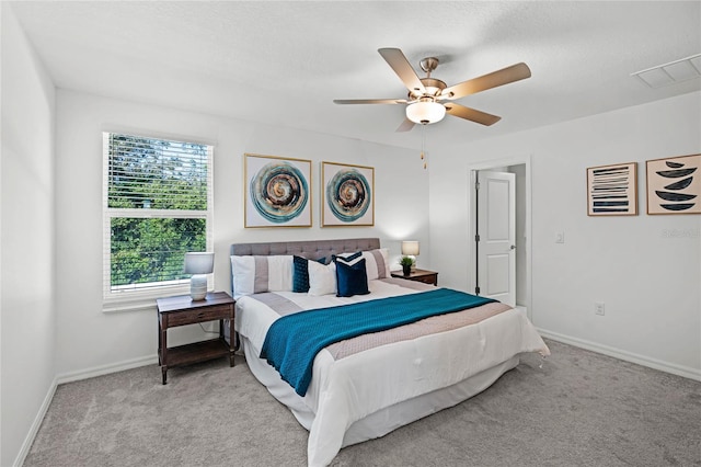 bedroom with multiple windows, ceiling fan, and light colored carpet