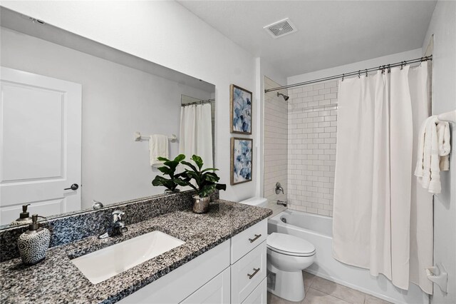 full bathroom featuring shower / bath combo with shower curtain, tile patterned floors, vanity, and toilet