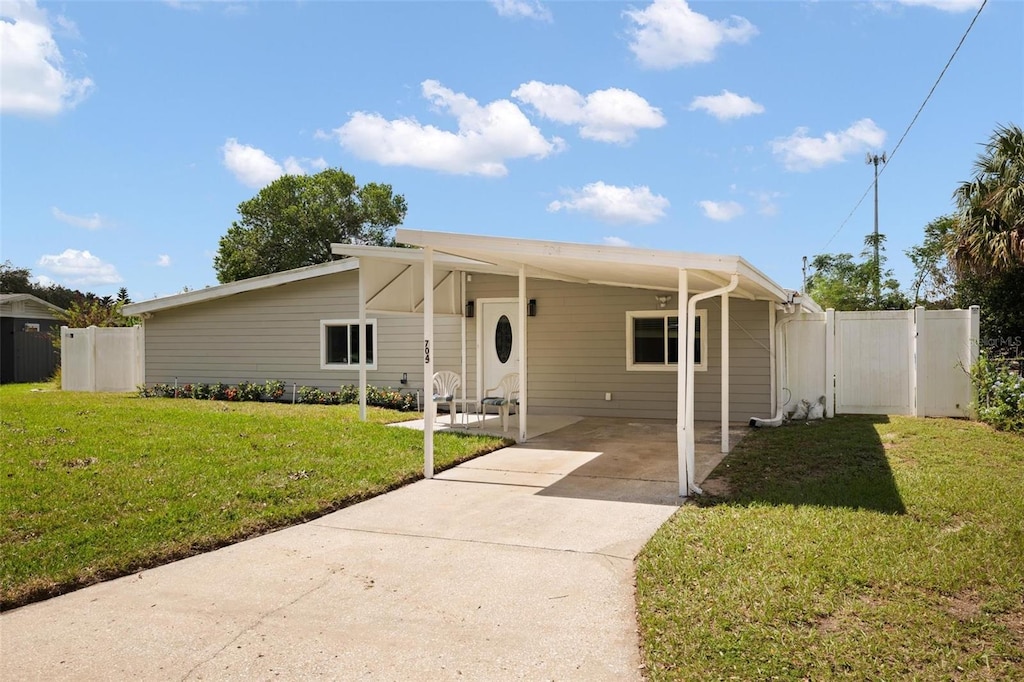 view of front facade featuring a front yard and a carport