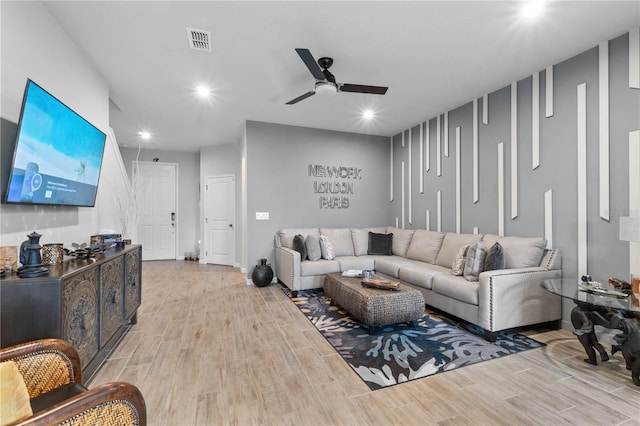 living room featuring ceiling fan and light hardwood / wood-style flooring